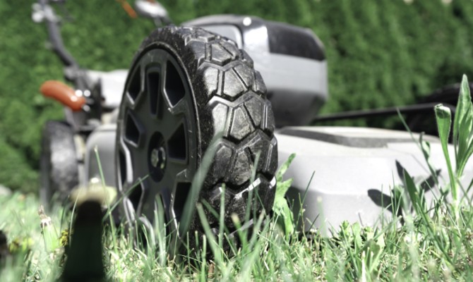 Close up of lawn mower mowing through grass.