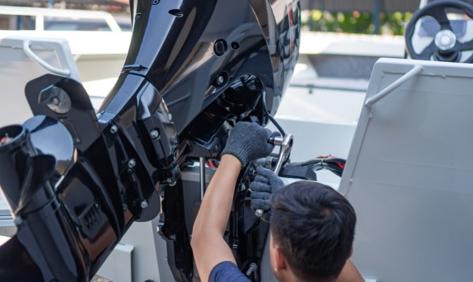 Technician working on boat motor.