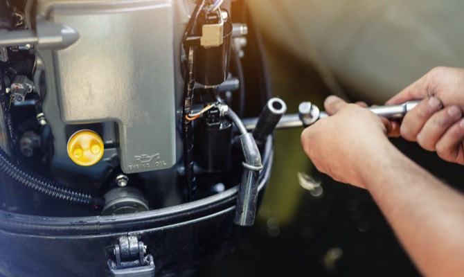 Technician repairing boat engine.