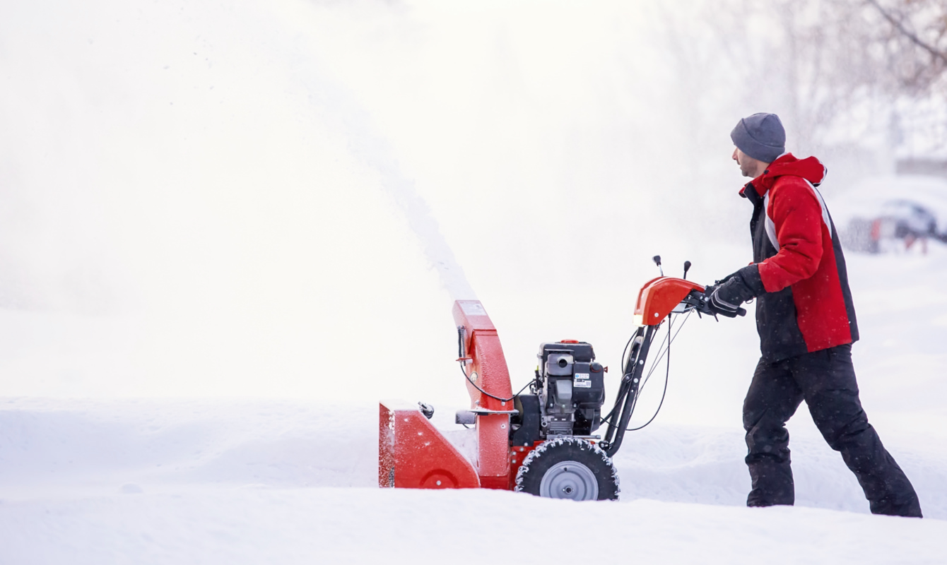 Man snow blowing driveway