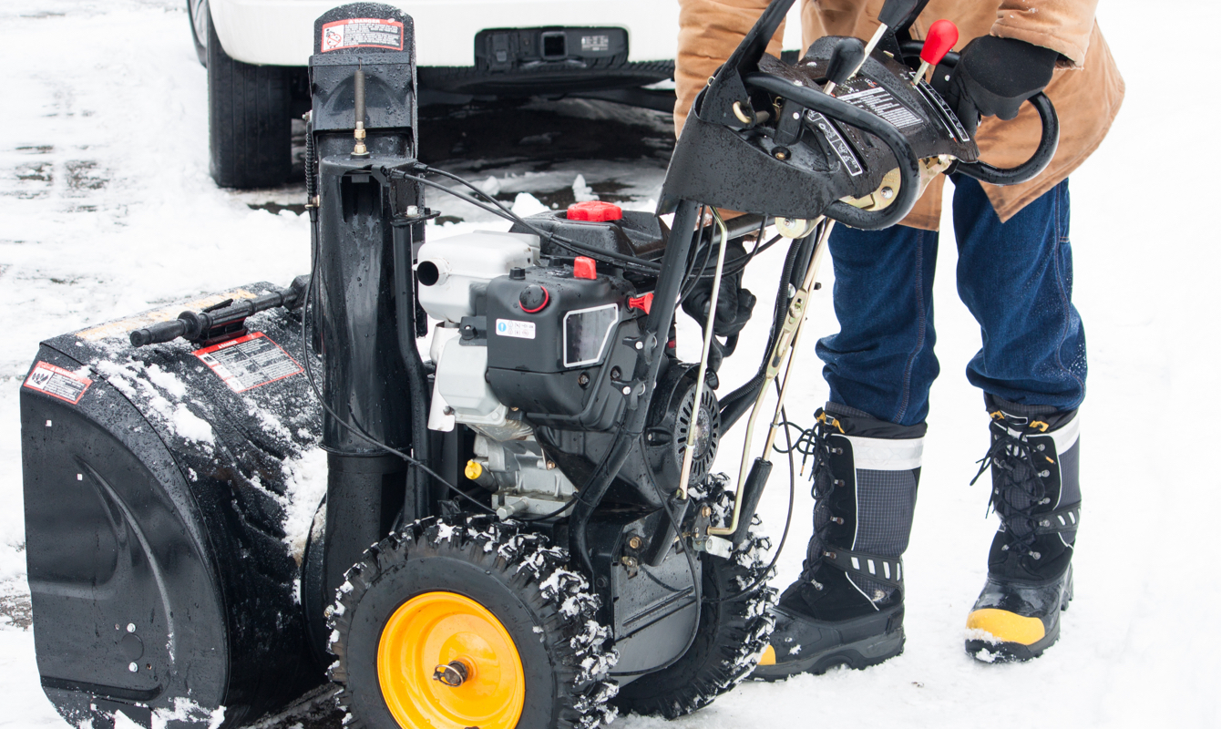 Man snow blowing driveway